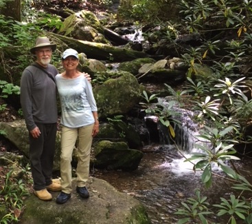 Debbie and her husband next to a waterfall
